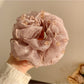 Top view of Gifty scrunchie with colorful beads arranged around beige fabric