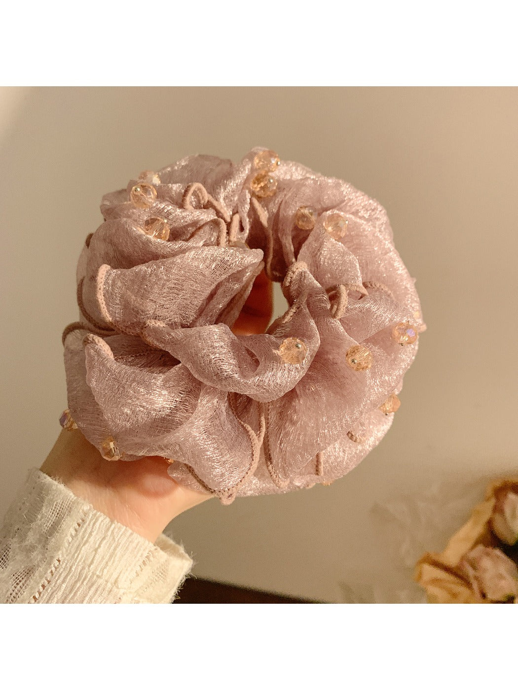 Top view of Gifty scrunchie with colorful beads arranged around beige fabric