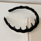 Pink corduroy headband displayed flat on white background showing full design