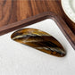 Beau oval ponytail clip shown from above with light reflecting on acetate surface