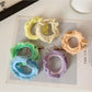 Ruffled hair ties in various colors stacked together showing texture and detail