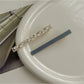 Beau hair clip resting on wooden surface with natural light highlighting colors