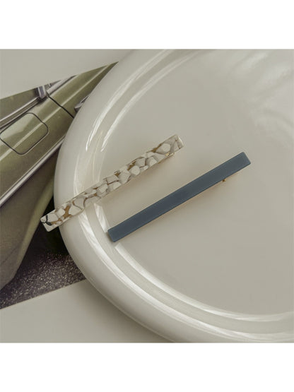 Beau hair clip resting on wooden surface with natural light highlighting colors