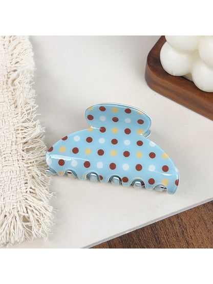 Blue hair claw clip with white polka dots shown from top angle