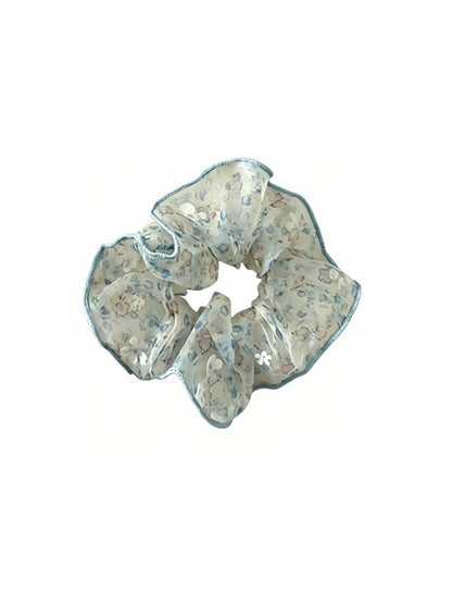 Gifty sheer tulle scrunchie styled in hair, emphasizing its delicate tiny floral pattern and sheer material