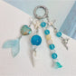 Minimalist ocean-inspired charm keychain with blue and silver accents on a keyring