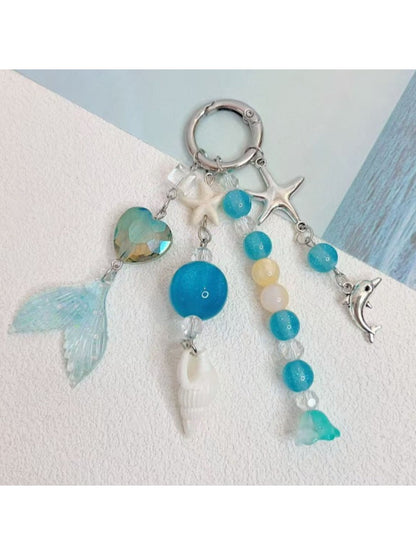 Minimalist ocean-inspired charm keychain with blue and silver accents on a keyring
