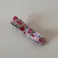 Beau hair clip displayed with matching pink floral accessories