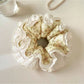 Gifty vintage floral ruched scrunchie styled in a woman's hair with loose curls