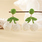 Pair of lightweight raffia cherry earrings with red woven cherries and green leaves