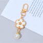 Flower charm keychain with vibrant colors and silver keyring on a wooden surface
