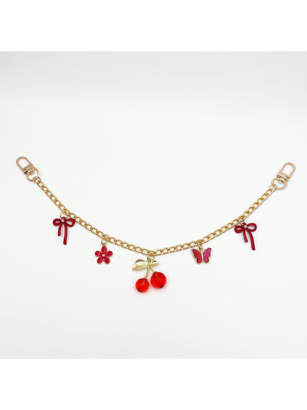 Minimalist cherry bag charm shown alongside a matching red wallet