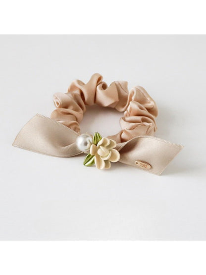Top view of Gifty hair tie highlighting the intricate floral design and elastic band