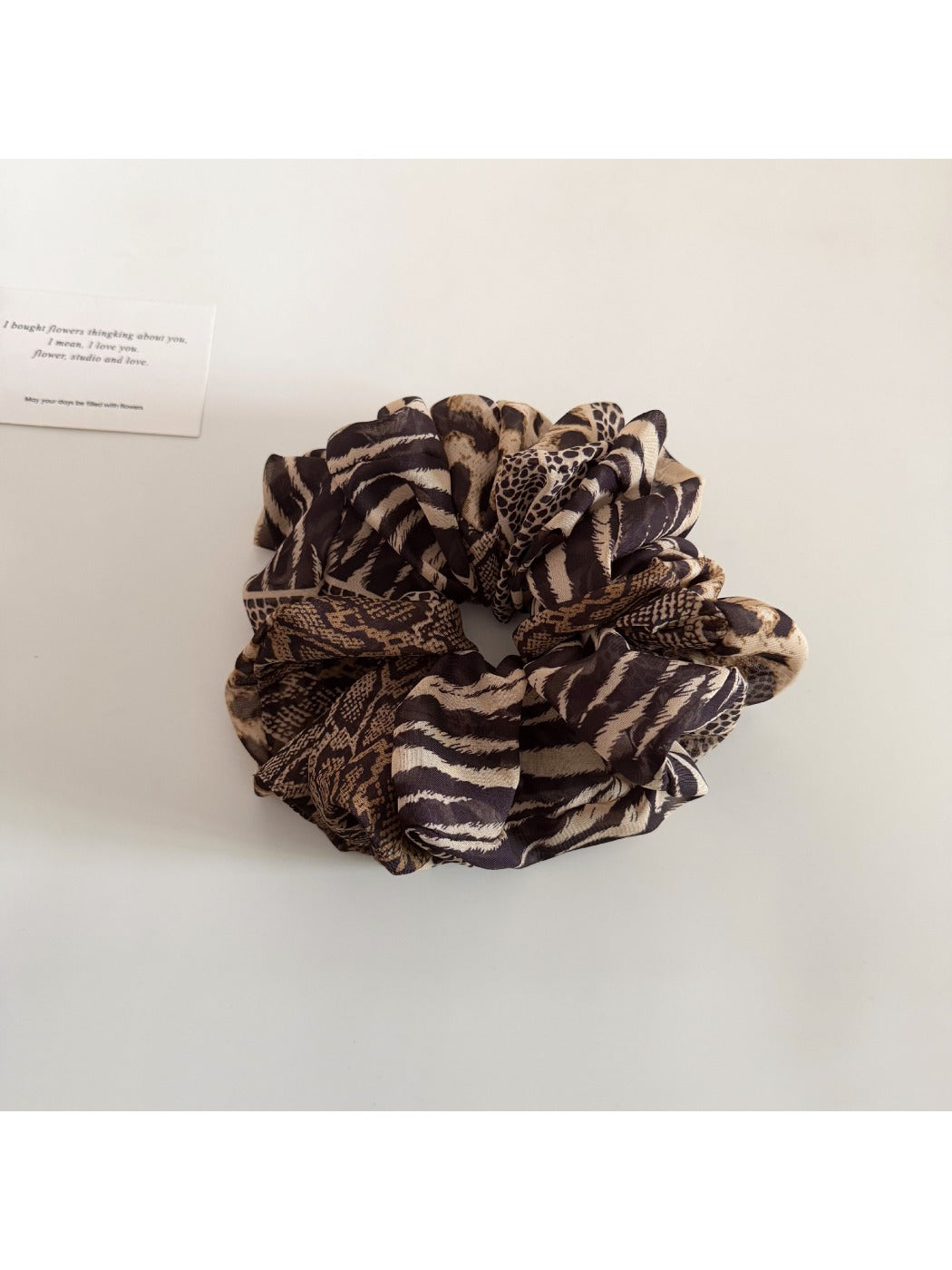 Leopard print ruched scrunchie photographed with natural lighting