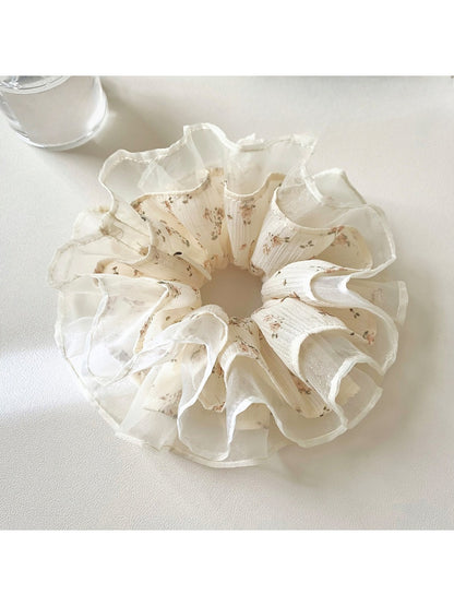Gifty scrunchie styled on a wrist, highlighting its delicate floral tulle design