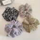Close-up of Gifty delicate daisy print scrunchie on white background