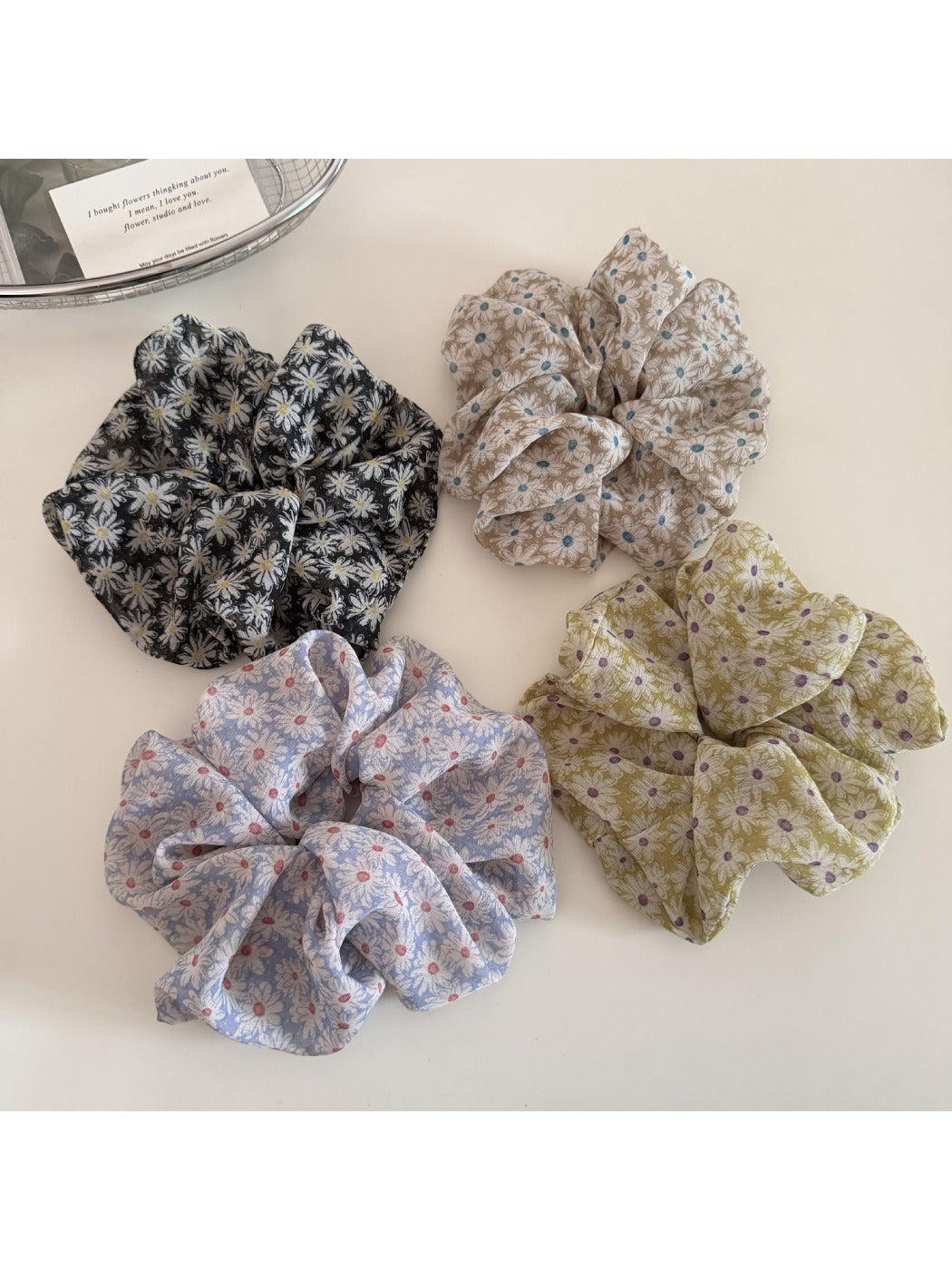 Close-up of Gifty delicate daisy print scrunchie on white background