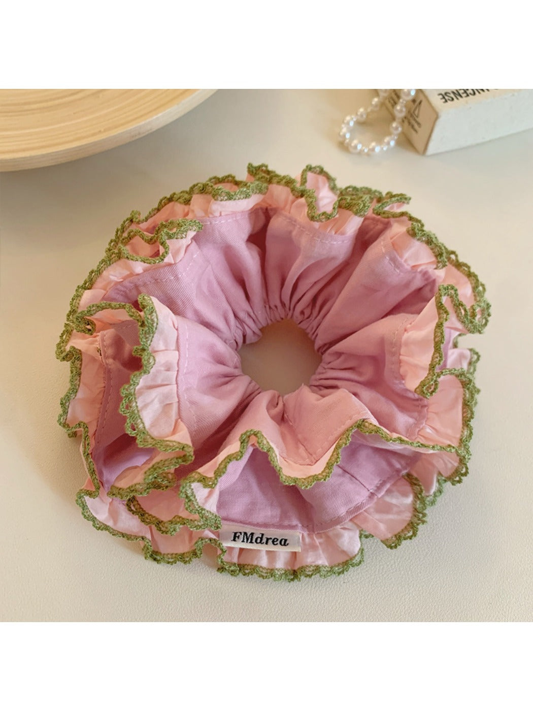 Pink double scrunchie with lace trim on a white background