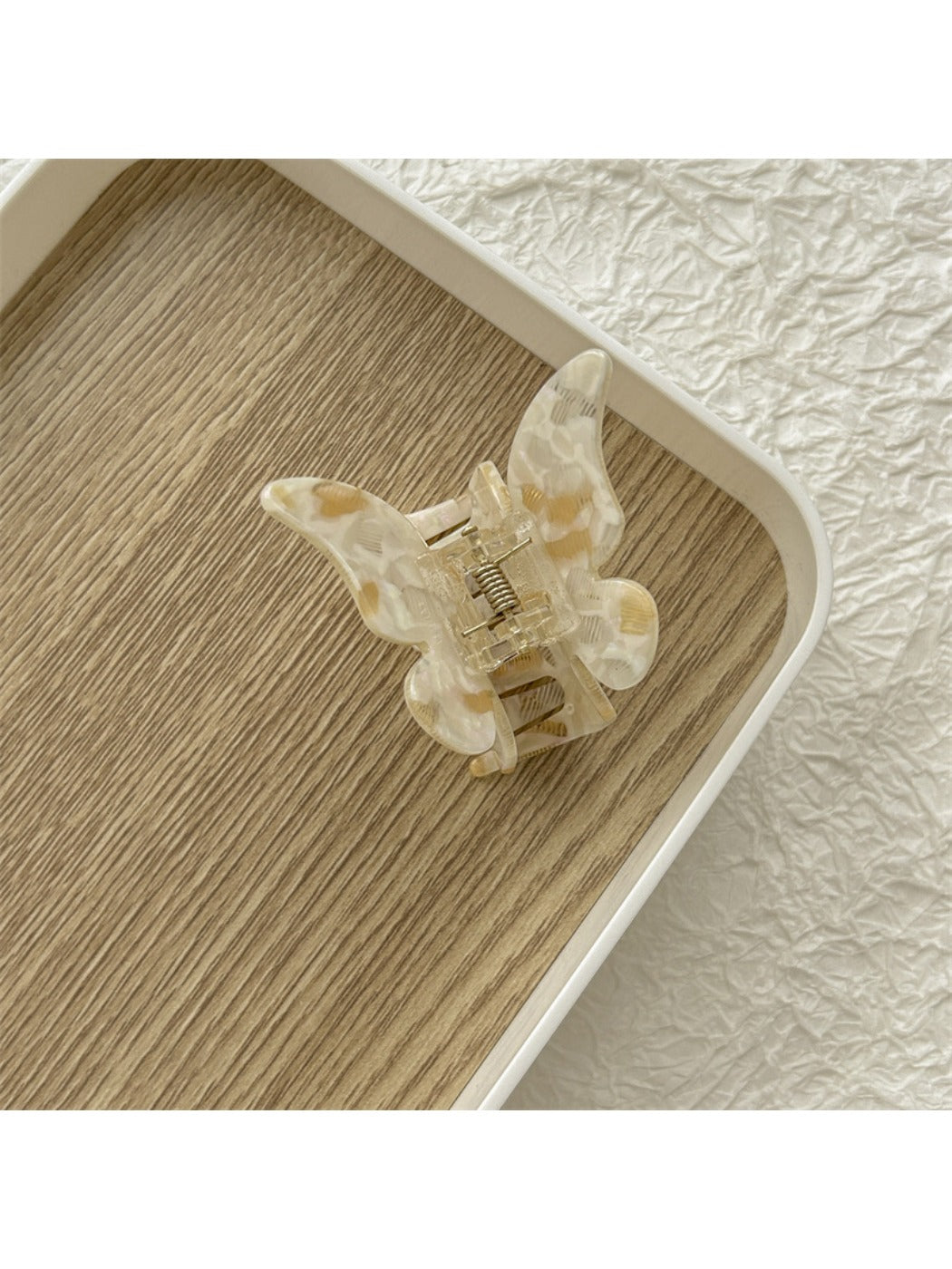 Beau light color butterfly claw clip placed on a wooden surface