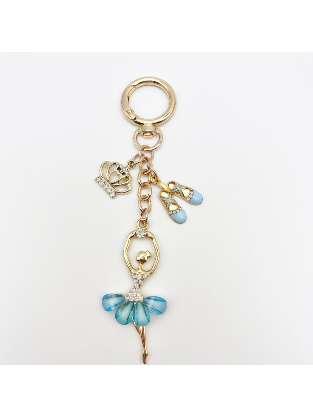 Ballerina charm keychain shown with other accessories on a wooden table