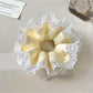 Yellow color block scrunchie wrapped around a ponytail in brown hair