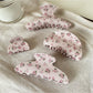Beau pink rose print hair claw clip on white background showing floral design