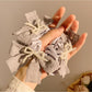 Side view of Gifty black lace bow scrunchie with white polka dots