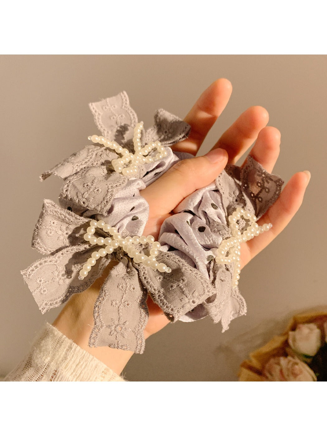 Side view of Gifty black lace bow scrunchie with white polka dots