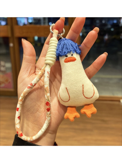 Blue duck keychain displayed with keys on a wooden table
