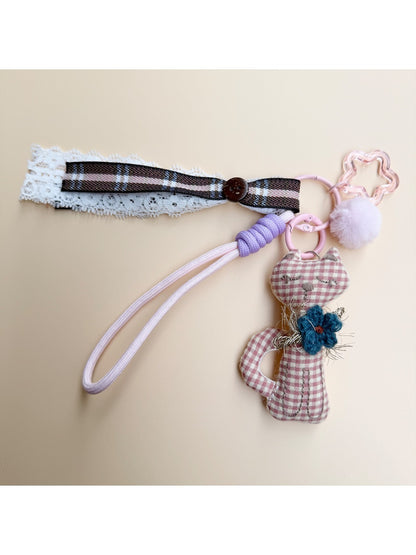 Fabric cat keychain hanging from a backpack zipper pull