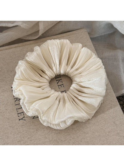 Close-up of the smooth satin material and ruched texture of the scrunchie