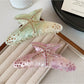 Side view of the colorful crescent hair claw clip highlighting its curved shape