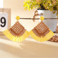 Detailed shot of woven raffia square design on vintage drop earrings with gold hooks