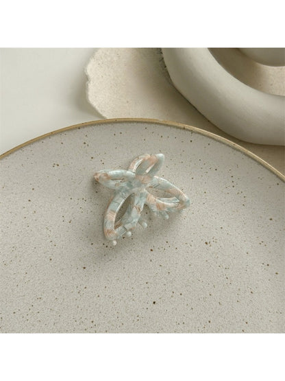 Beau butterfly claw clip in natural light emphasizing translucent acetate colors