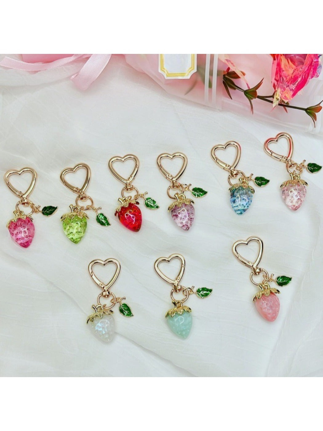 Close-up of Keypus strawberry charm keychain with silver ring on white background