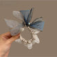 Close-up of elegant bow embellished hair tie in soft pink fabric