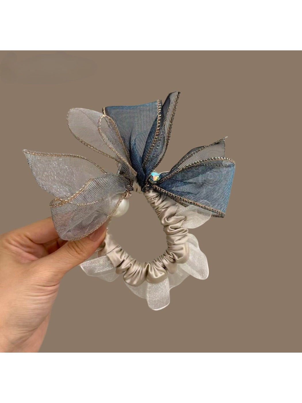 Close-up of elegant bow embellished hair tie in soft pink fabric