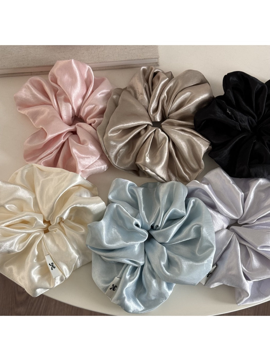 Close-up of glossy satin scrunchie fabric texture in pink