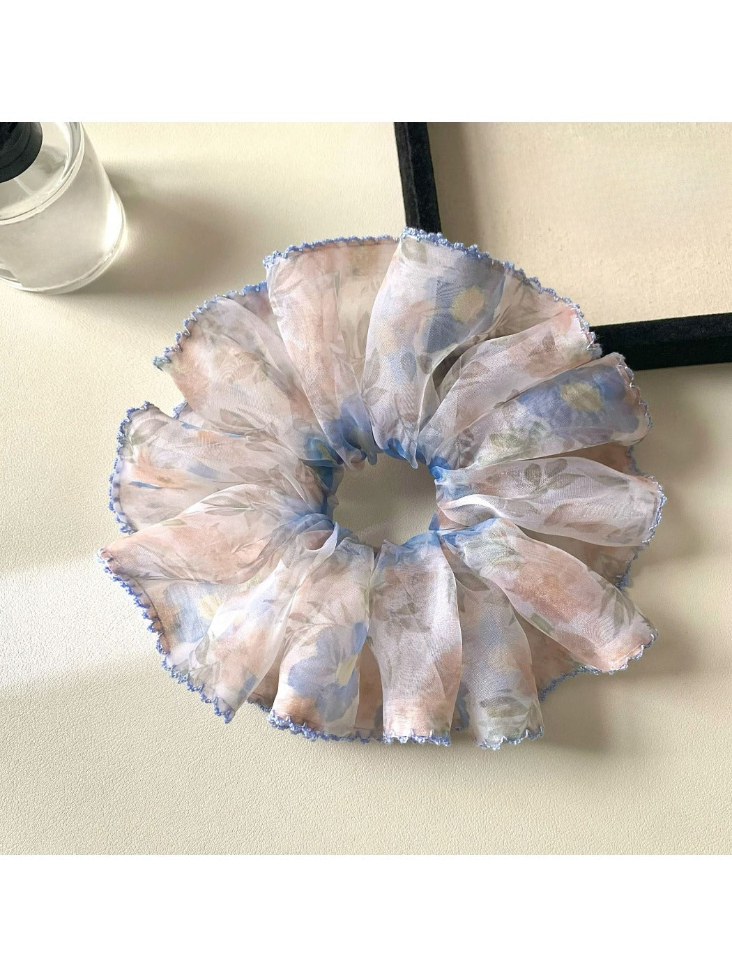 Multiple printed scrunchies stacked together showing different vintage designs