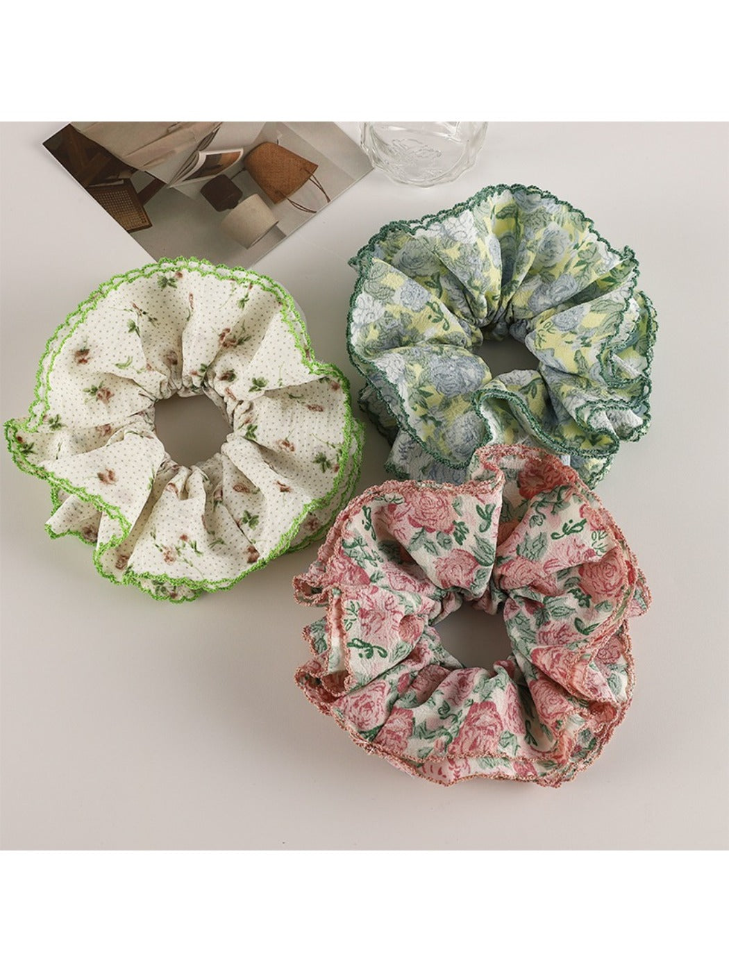 Close-up of Gifty trendy floral print scrunchie with pink and white flowers on fabric