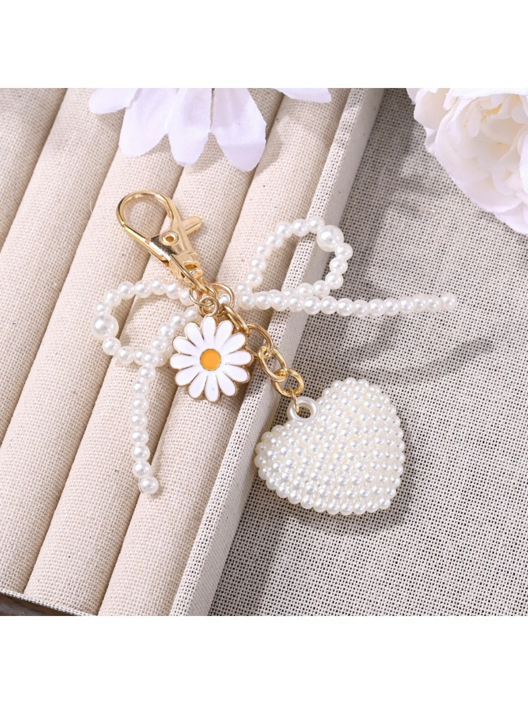 Close-up of pink bow heart shaped keychain showing texture and gold ring