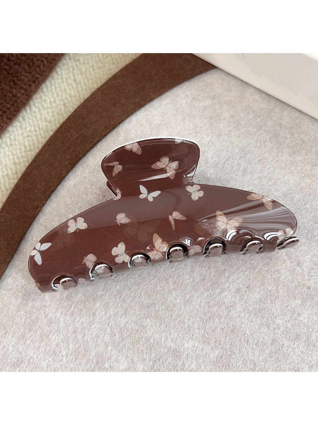 Top view of brown butterfly print claw clip showing symmetrical pattern