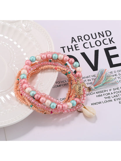 Lovra bracelet with tassel charm and mixed beads arranged in a circle