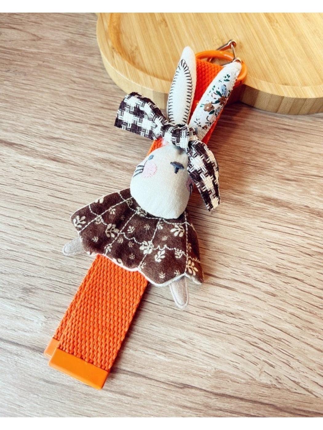 Fabric rabbit keychain hanging from a bag strap with metal keyring visible