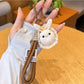 Bunny keychain attached to a handbag strap, highlighting size and portability