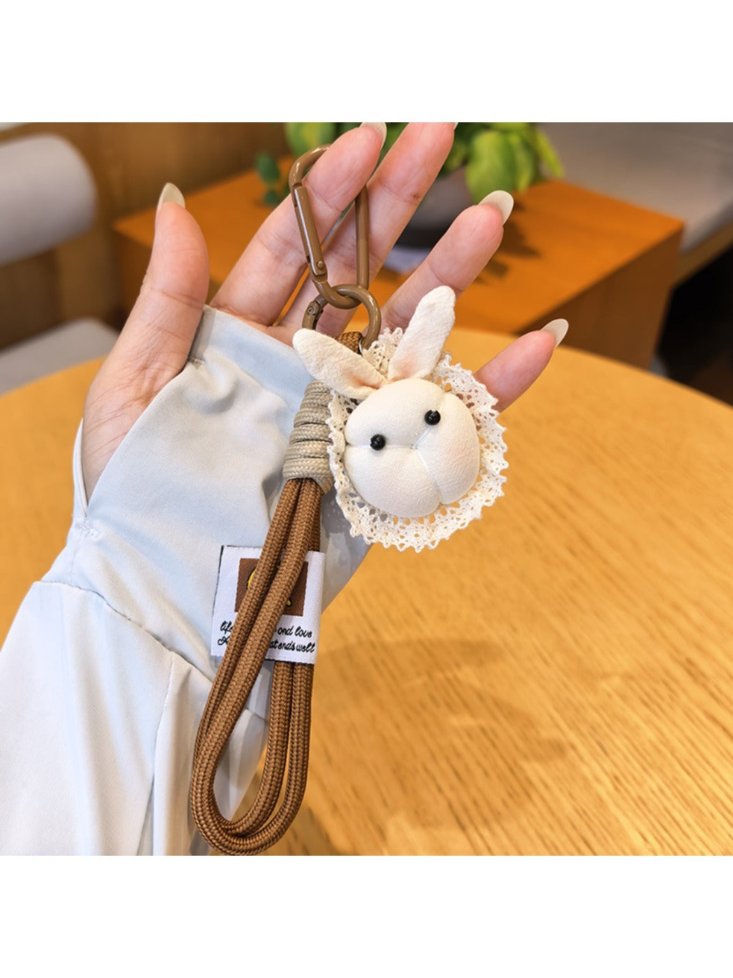 Bunny keychain attached to a handbag strap, highlighting size and portability