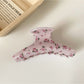 Beau hair claw clip with pink rose design photographed from above