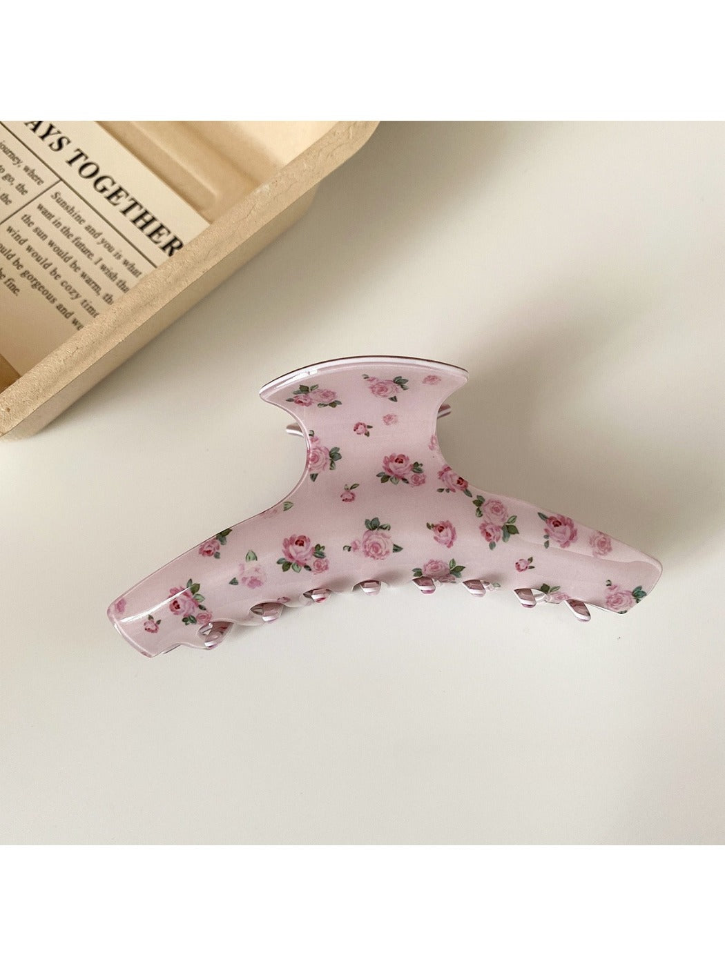 Beau hair claw clip with pink rose design photographed from above