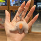 Elephant charm keychain shown with a close-up of the keyring attachment
