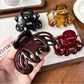 Beau claw clip open, displaying spring mechanism and curved design